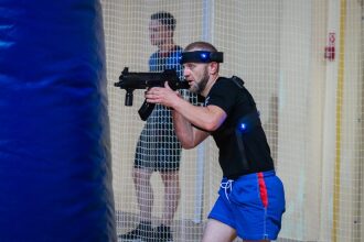 Боец LASERWAR в движении за синим укрытием.